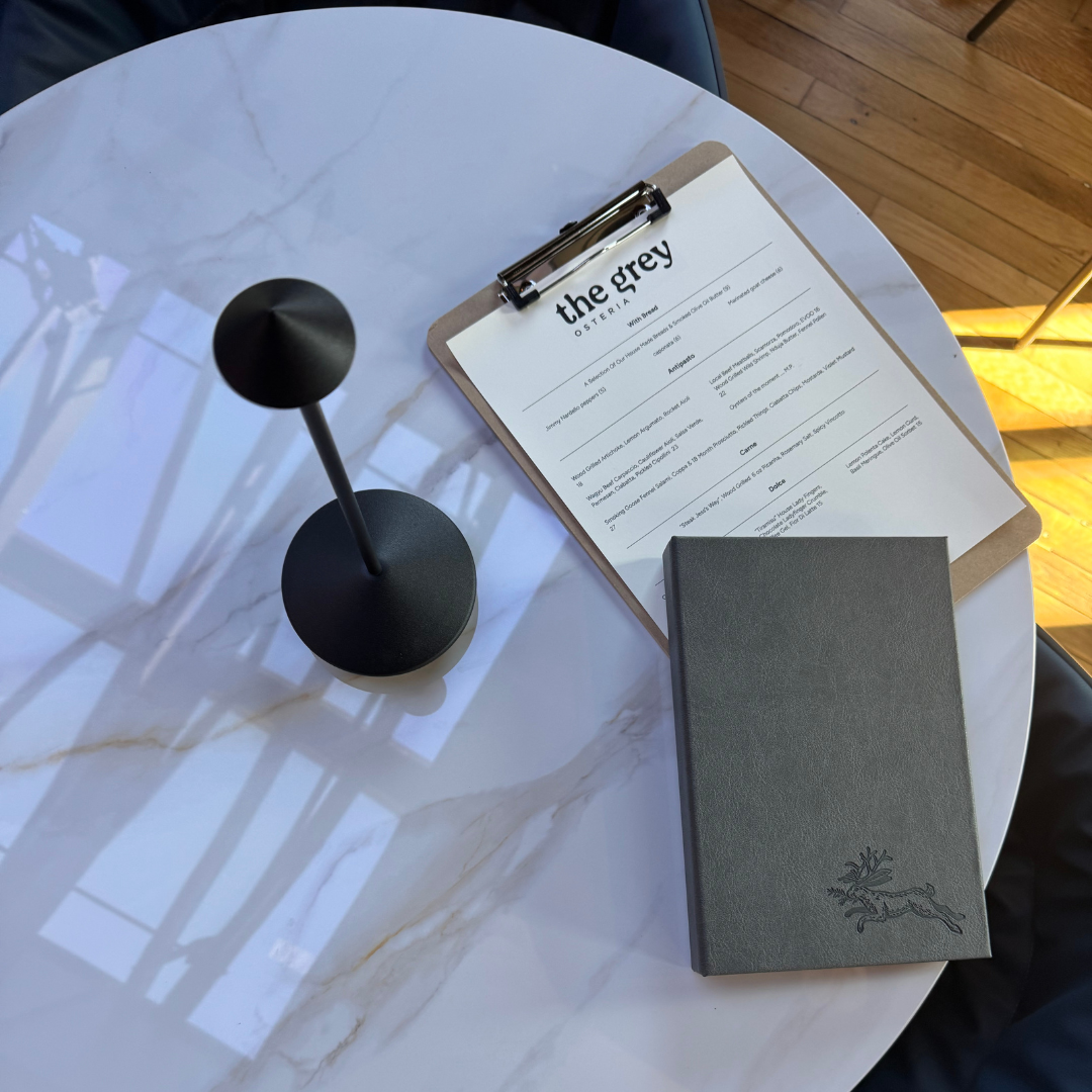 a dining menu laying on a white marble table